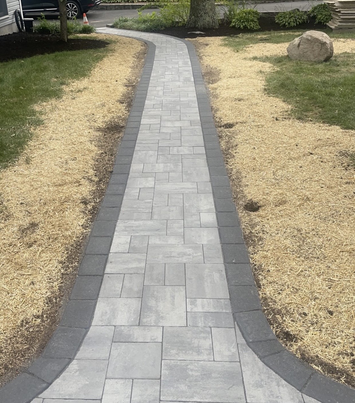 Curved gray paver walkway with a charcoal border