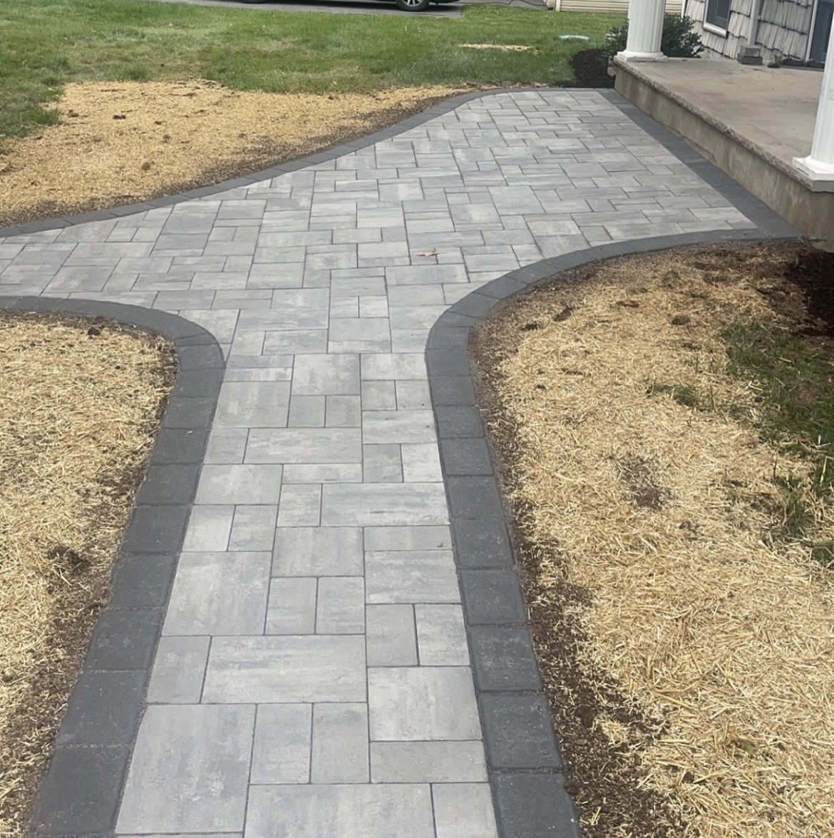 Paver walkway curving to a front porch